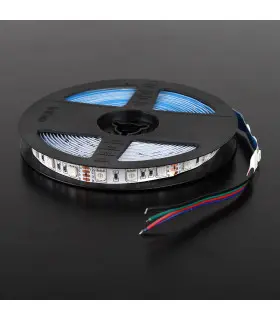 RGB LED strip on a reel with wires: A roll of RGB LED strip on a black reel with colour-coded wires, placed on a dark surface