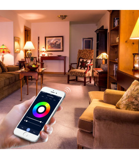 A person using a smartphone app to control the MiBoxer RGB+CCT LED bulb, changing light colours in a cosy living room setting.