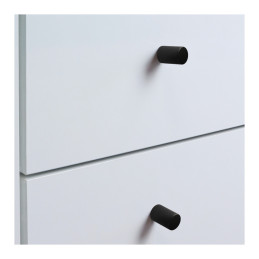 Matte black furniture knobs on white drawer fronts.