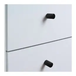 Matte black furniture knobs on white drawer fronts.