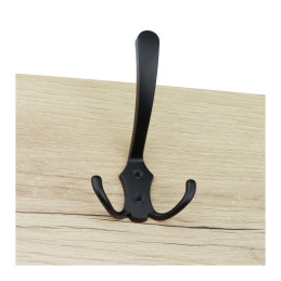 Black metal coat hook mounted on a light wooden surface.