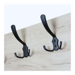 Two black hooks mounted on a wooden surface