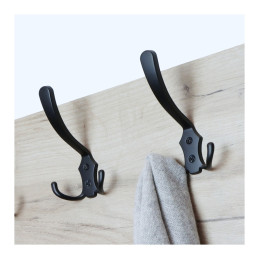 Two hooks on a wooden surface, one holding a grey fabric item