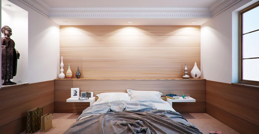 Bedroom with recessed LED lights: Modern bedroom with wood accent wall, soft bedding, and warm recessed LED downlights.