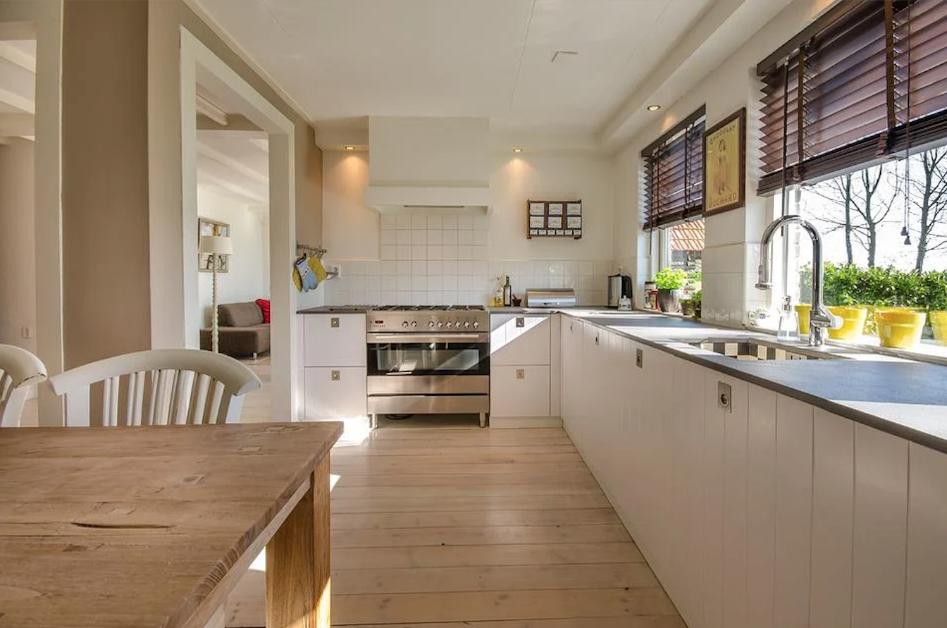 Bright kitchen with LED task lighting: Cosy kitchen with white cabinets, stainless appliances, and bright under-cabinet LED lighting.