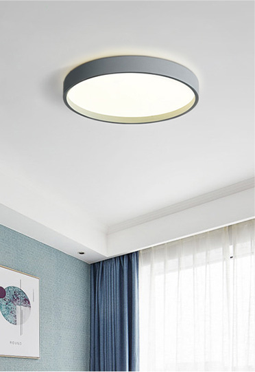 Round LED ceiling light fixture in a modern home interior with blue curtains.