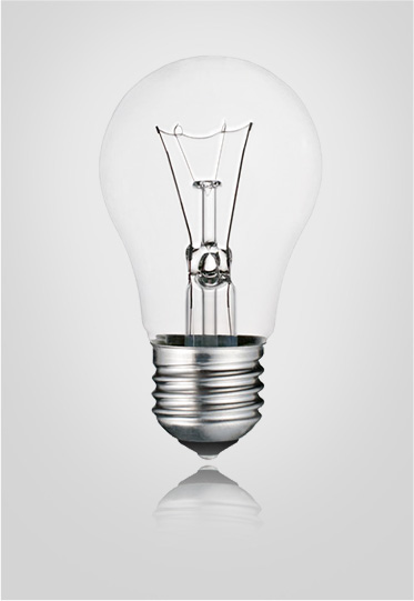 Traditional filament light bulb with clear glass and standard screw base, standing upright.